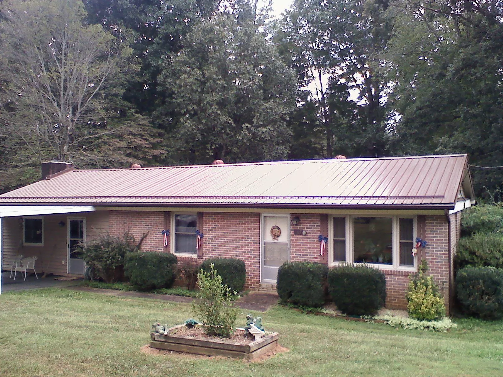 Bronze metal roof on a brick ranch home with a carport in Joliet