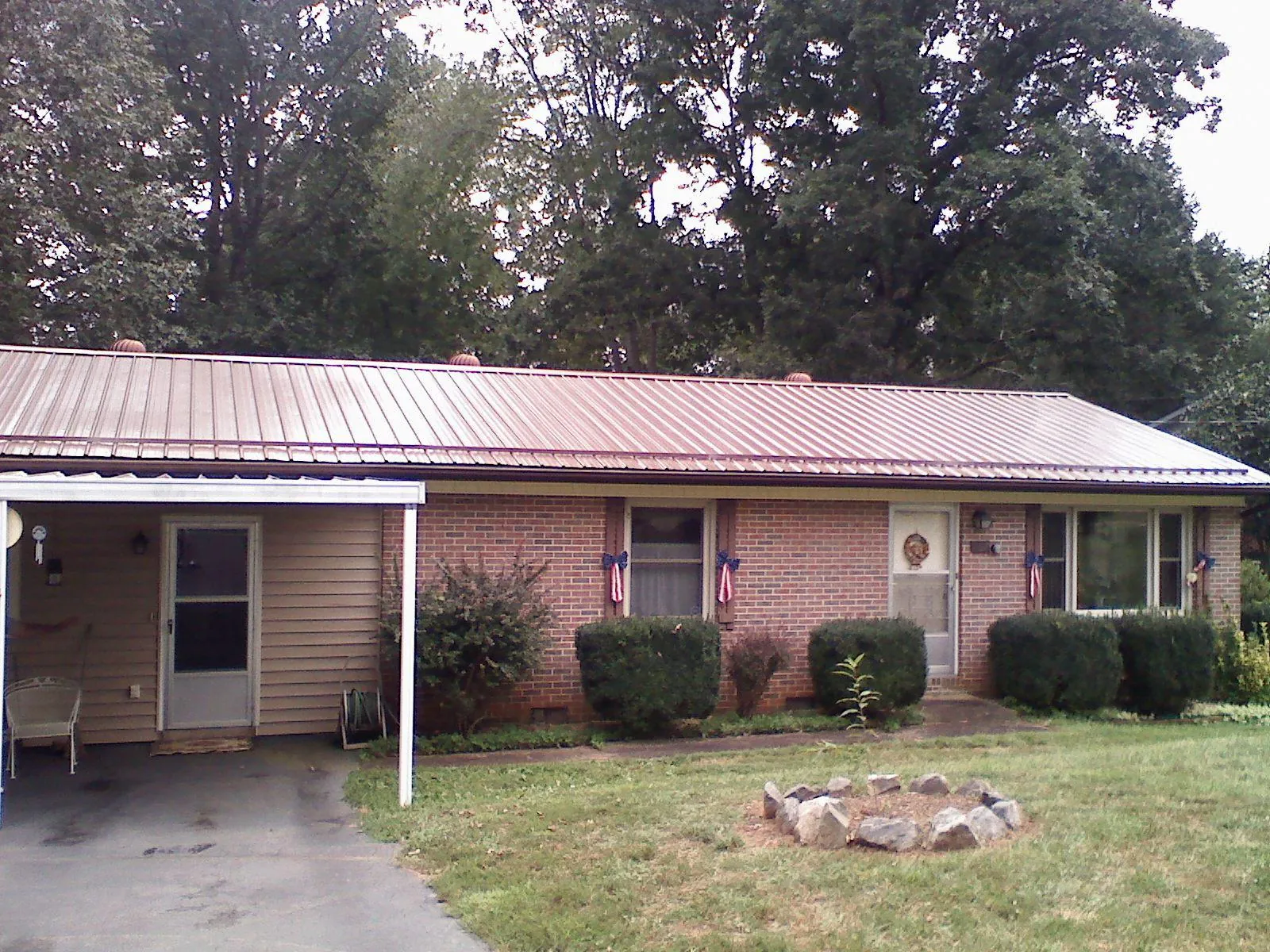 Bronze metal roof and carport on a brick ranch home — Roof Repair work by our crew in Joliet